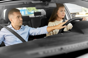 Moniteur d'auto-école accompagnant une élève conductrice pendant une leçon de conduite