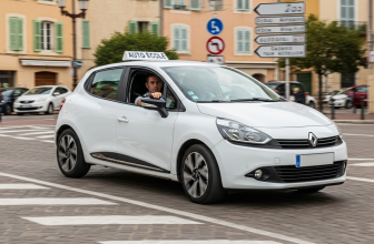 Voiture auto-école blanche en leçon de conduite dans le centre-ville de Gardanne, passant devant des panneaux de signalisation